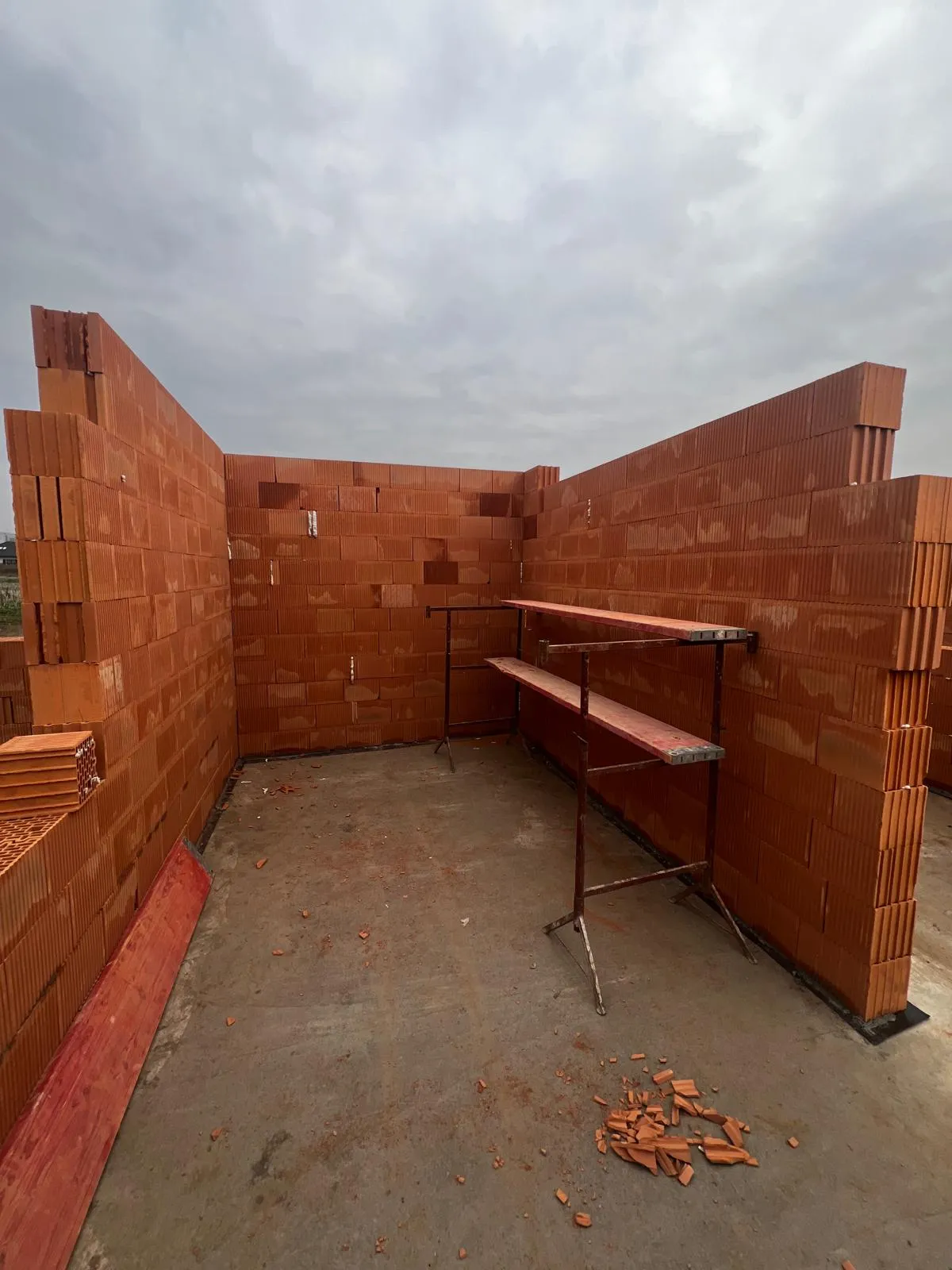 Murowanie ścian nośnych z pustaków ceramicznych - widok wnętrza budowy domu na etapie stanu surowego otwartego