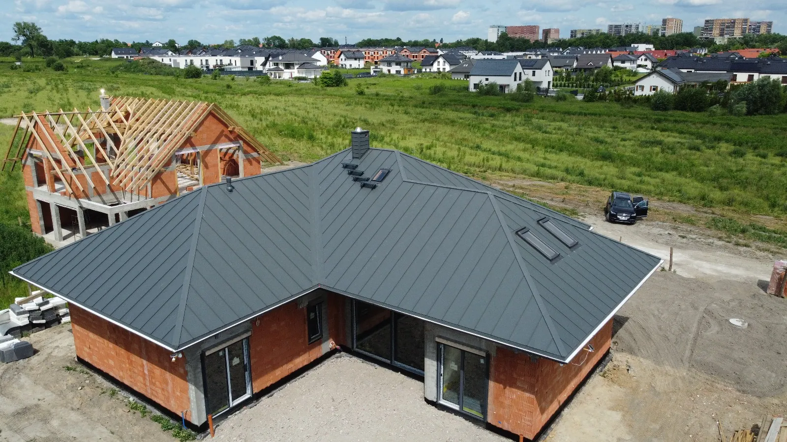 Gotowy dach z blachy na rąbek stojący — widok z drona na dom parterowy w Zabrzu