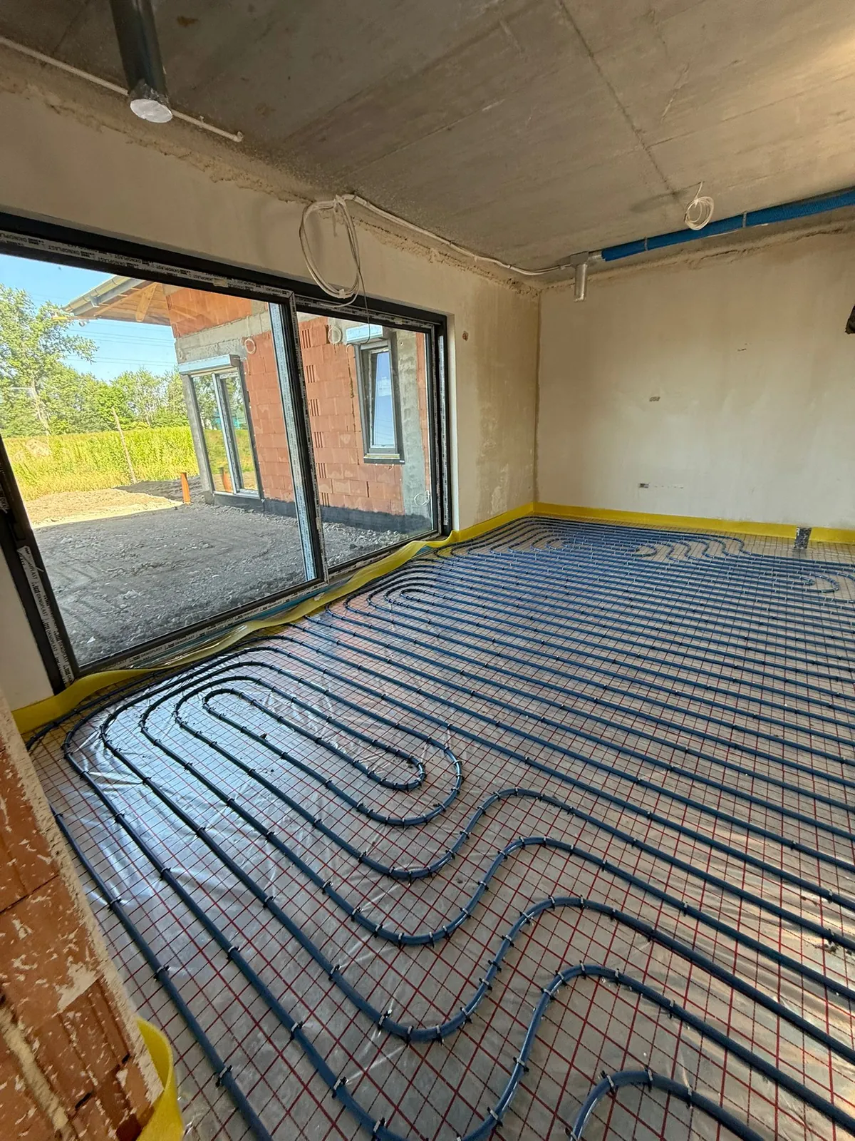 Salon z ogrzewaniem podłogowym i dużymi oknami tarasowymi