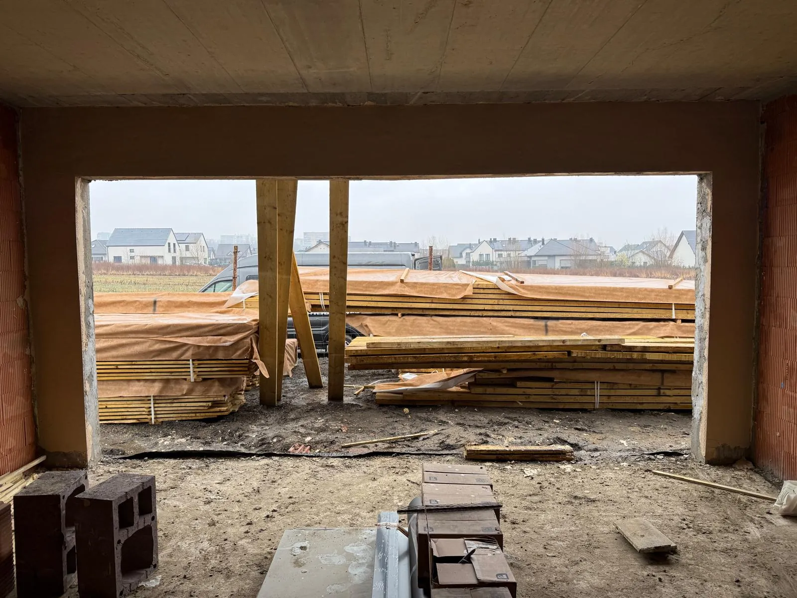 Widok z garażu na strop monolityczny i przygotowane drewno na więźbę